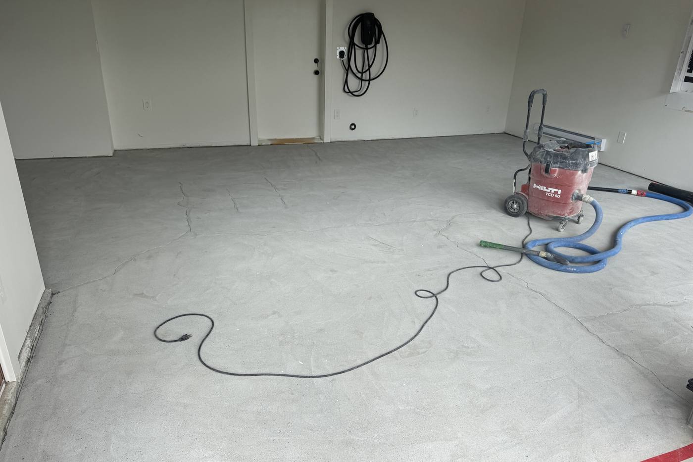 Diamond grinding concrete garage floor with dust extraction before epoxy coating