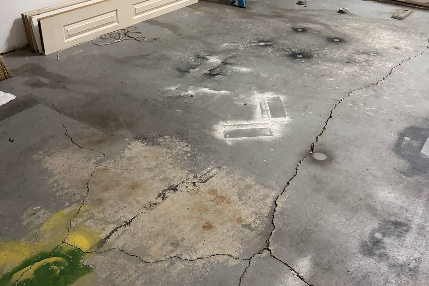 Cracked and stained concrete garage slab inspected before epoxy coating