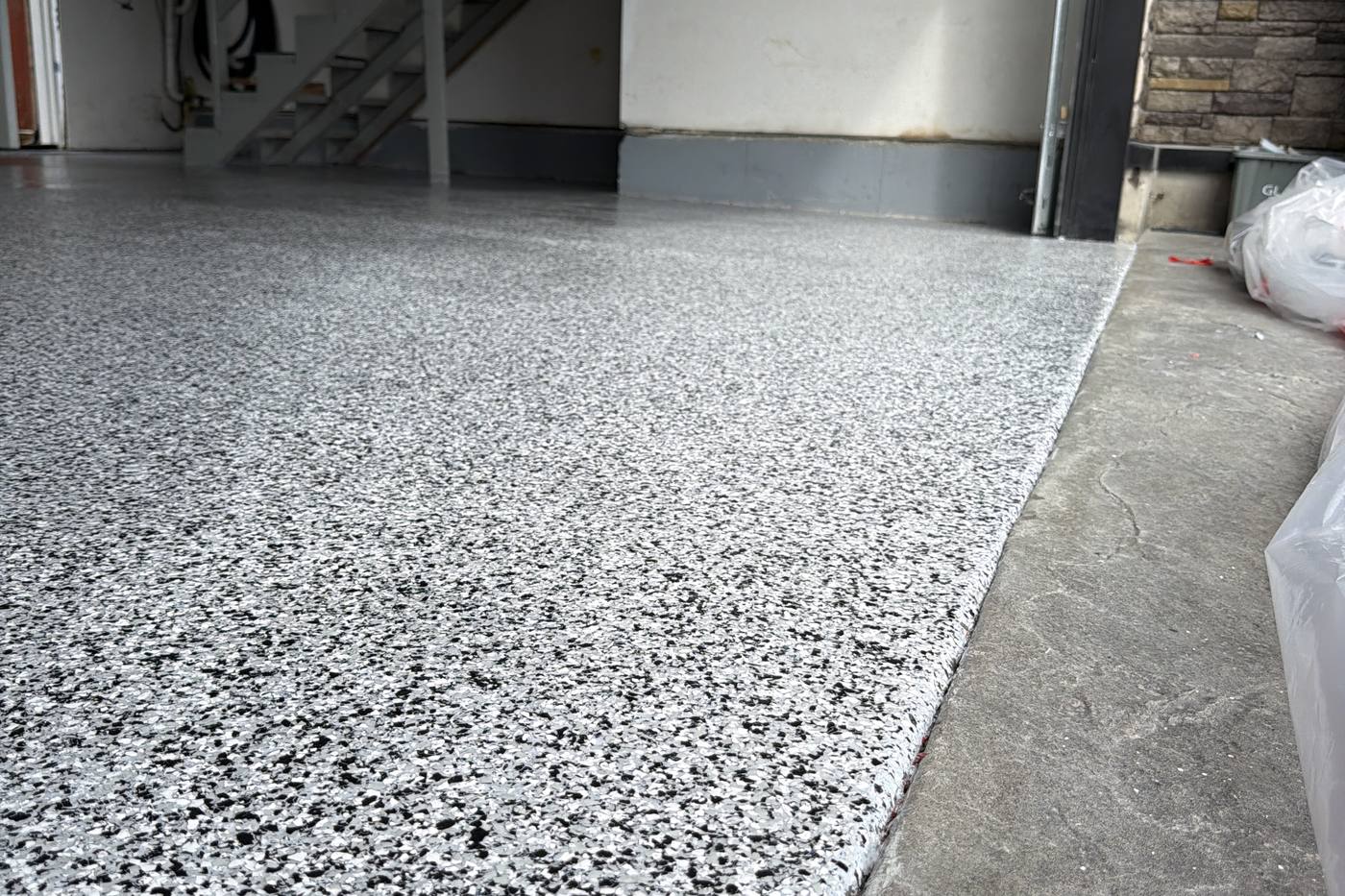 Finished epoxy garage floor in Coquitlam meeting the driveway threshold