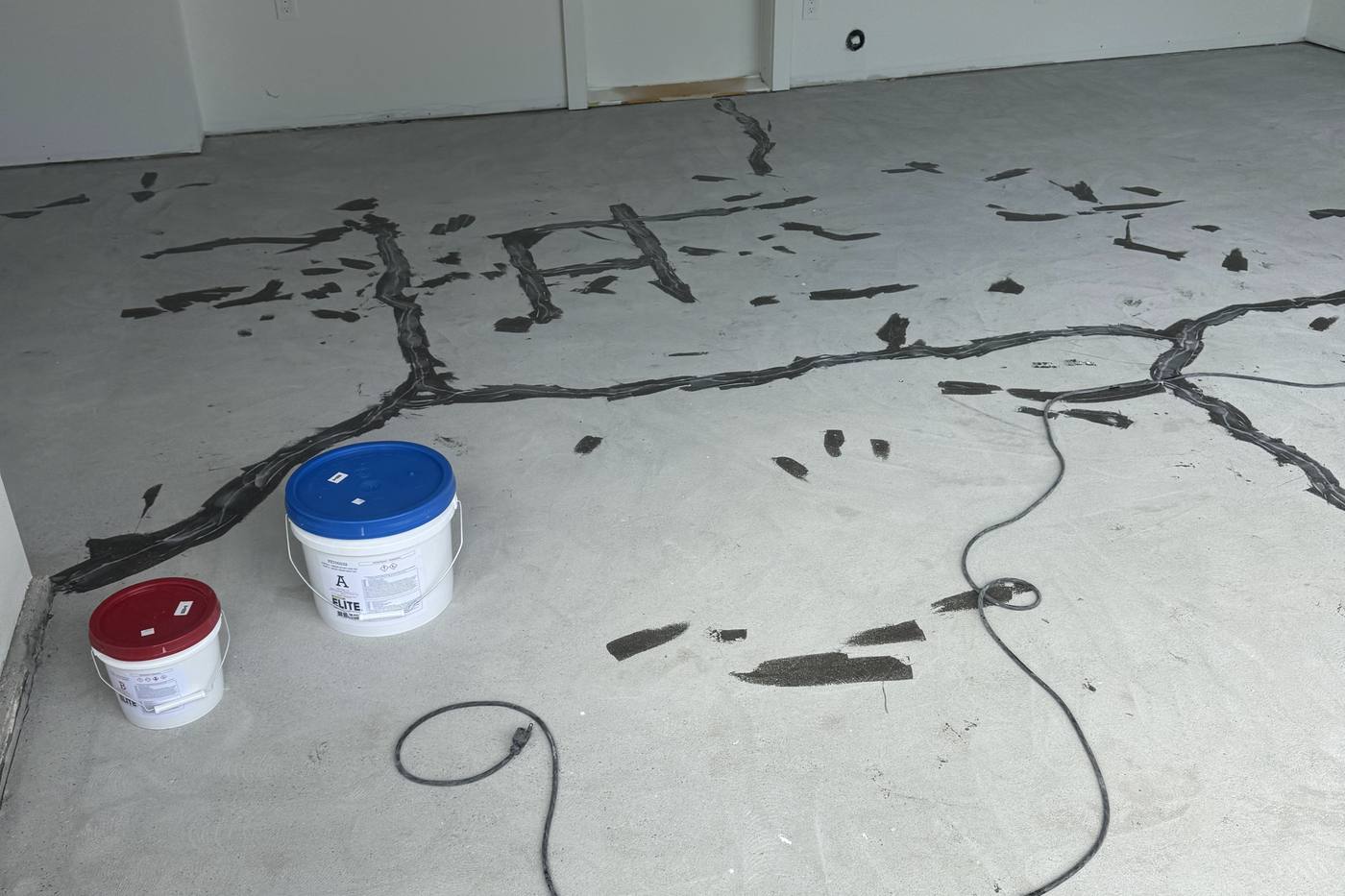 Repairing cracks with two-part compound before garage floor epoxy installation