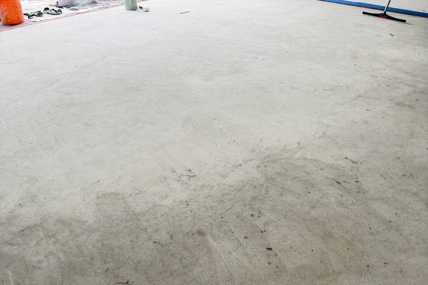 Prepared and masked concrete garage floor ready for the epoxy base coat